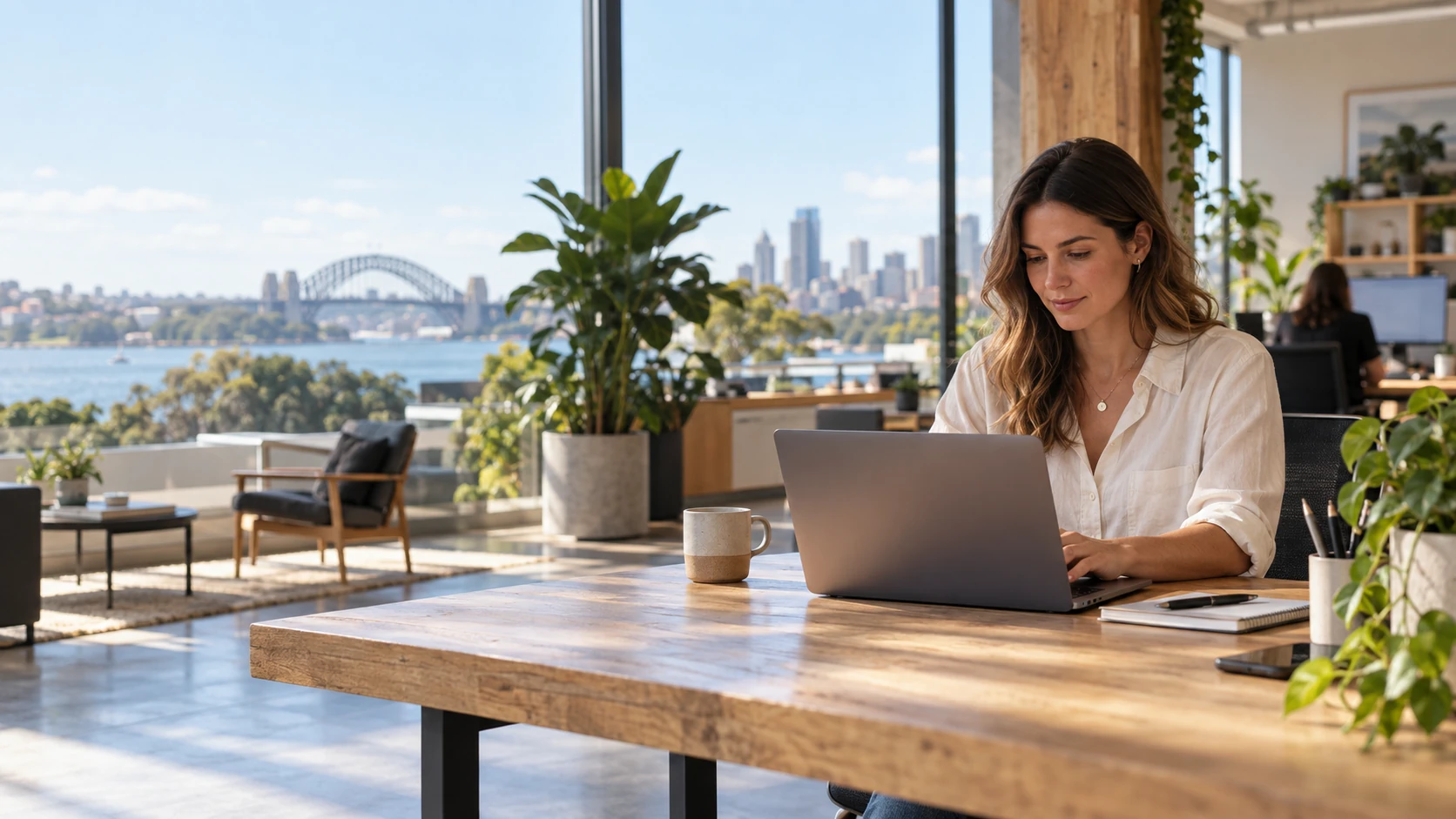 A woman working on a laptop in a bright Australian city workspace